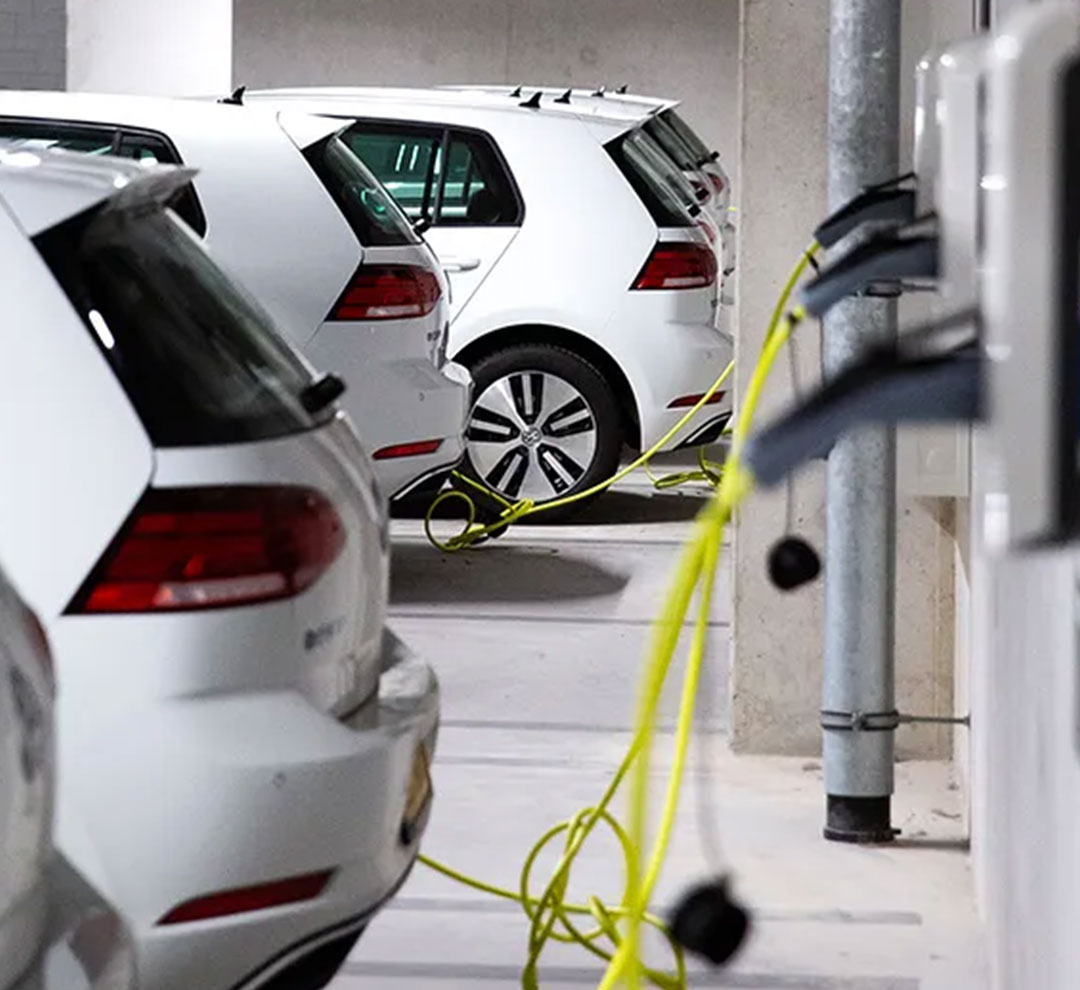 six electric cars charging in a parking garage